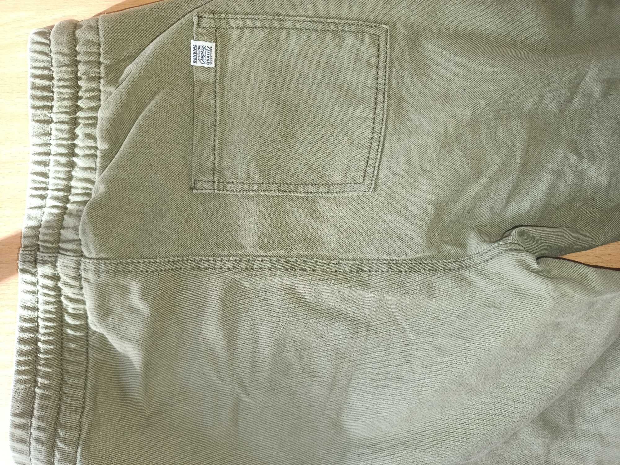 Oliwkowe spodnie chłopięce H&M.