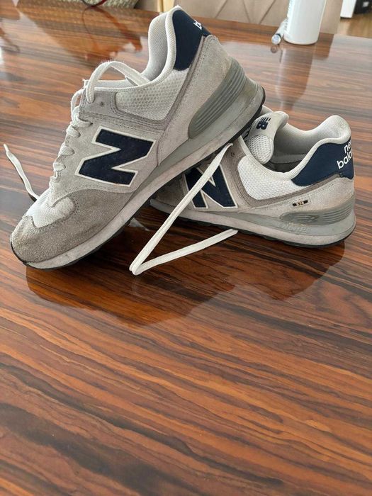 Tenis NIKE New Balance 574 cor cinza clara.