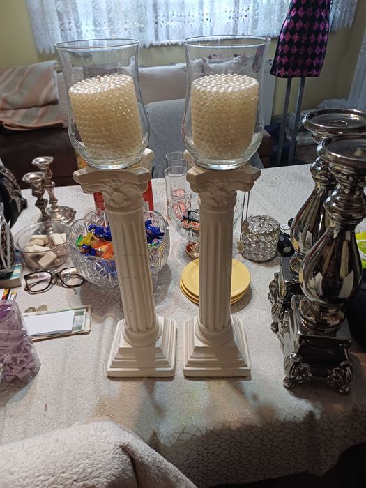 Dwa ceramiczne świeczniki ze świecami.