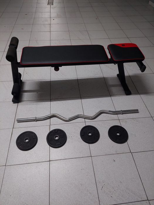 Bancada de musculação, barra e alguns discos