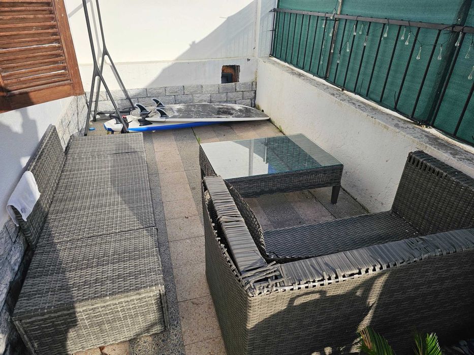 Conjunto de jardim com mesa, espreguiçadeira e sofá.