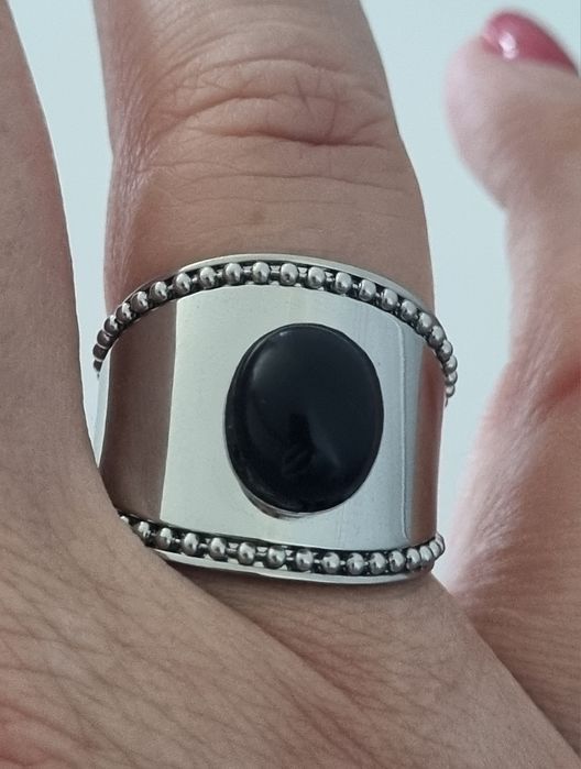 Anel prateado, em aço  com pedra preta oval. Ajustável