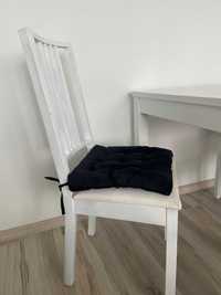 Białe krzesła wraz z poduszką