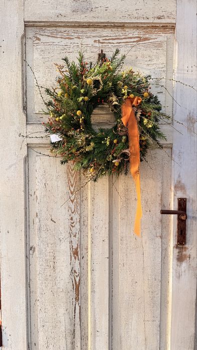 Jesienny wianek z gałązkami modrzewia i pomarańczową kokardą