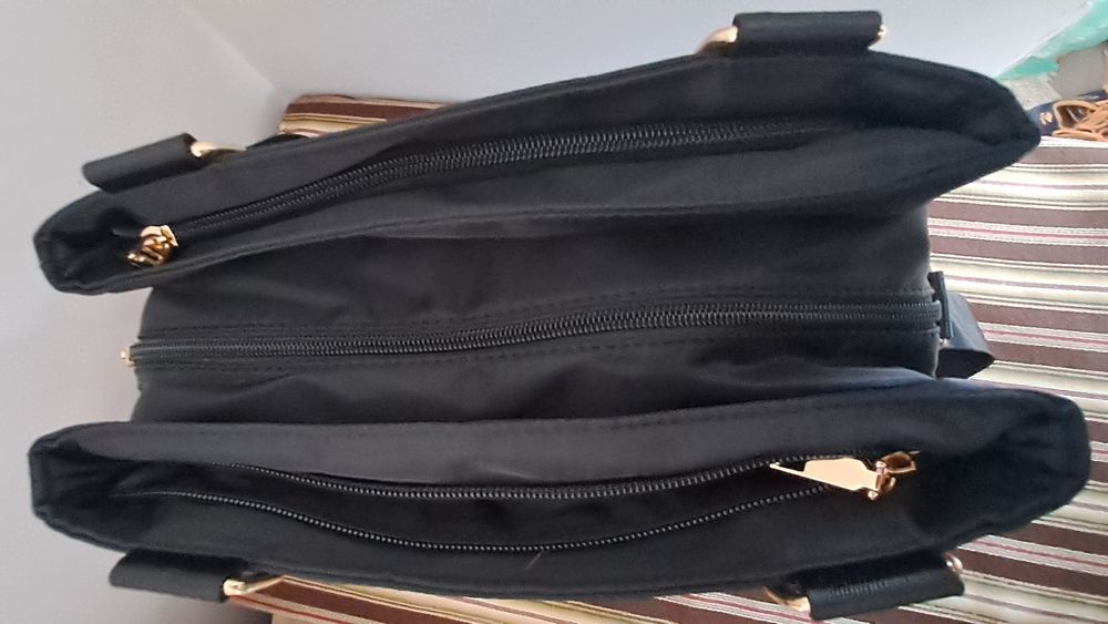 Carteira preta em tecido impermeável com várias divisórias, pratica e