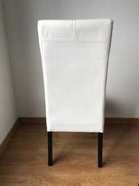 Cadeiras forradas a napa branca com pés de madeira em preto