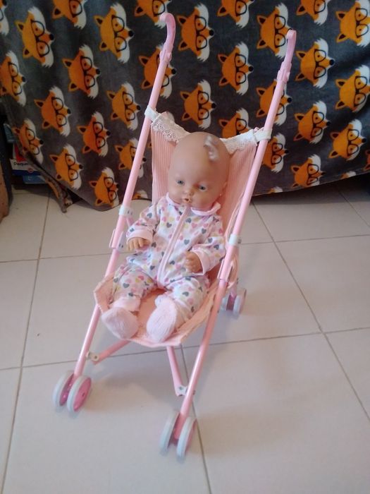 Bebé no carrinho rosa.