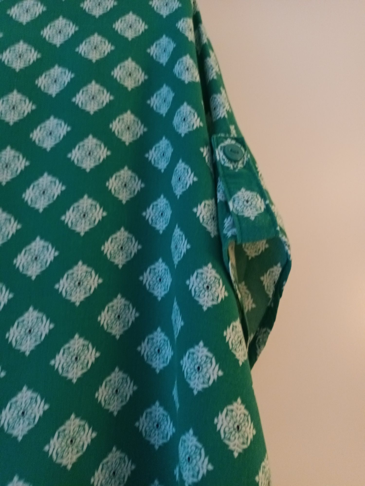 Blusa verde com padrão de flores brancas