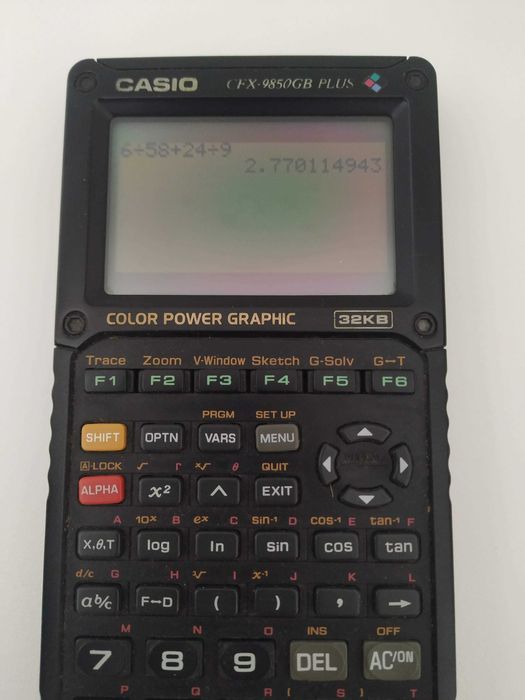 Casio CFX-9850GB Plus — calculadora gráfica, com tampa, a funcionar