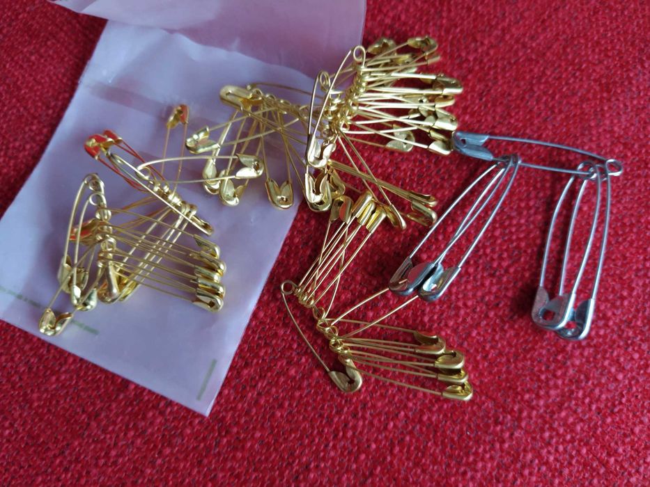 Embalagem com alfinetes de ama dourados e prateados
