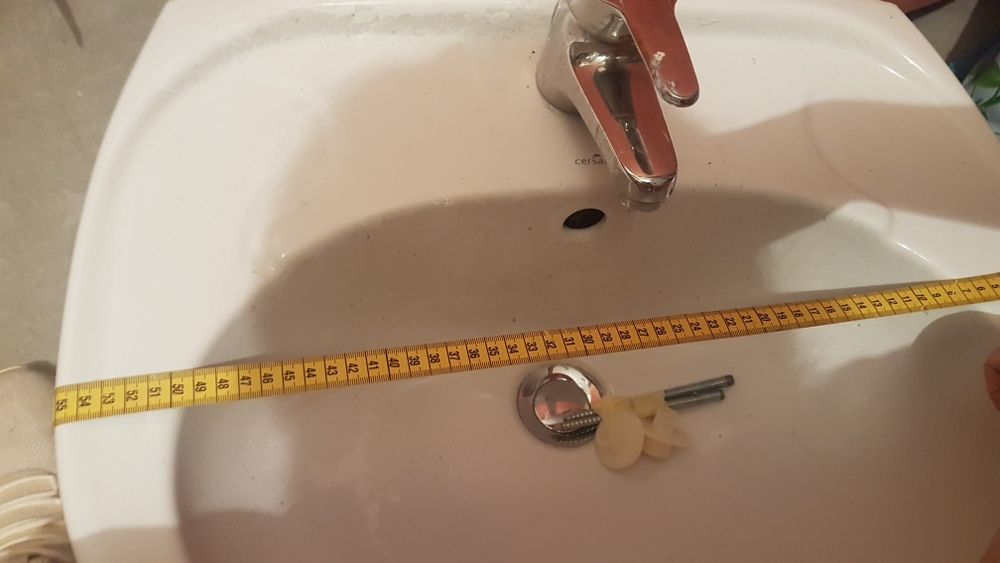 Umywalka biała z baterią i rurkami