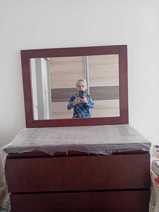 Lustro z brązową ramką.