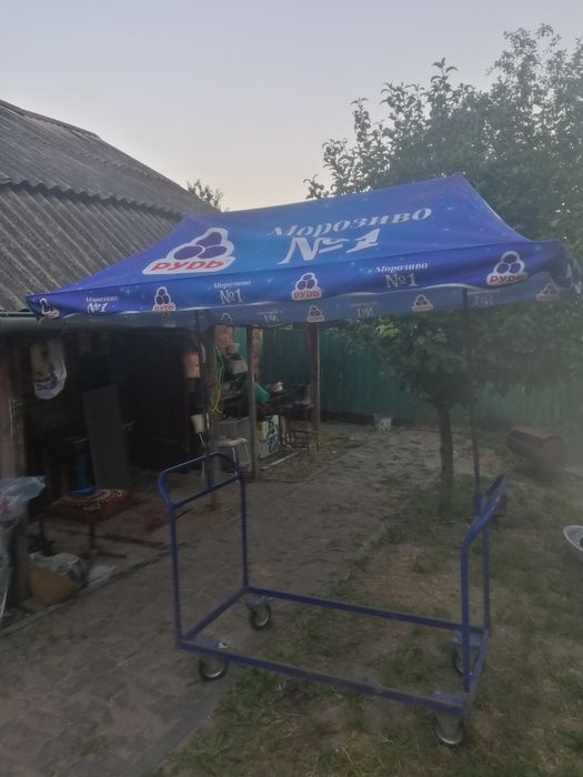 Вуличний торговий візок із синім навісом.