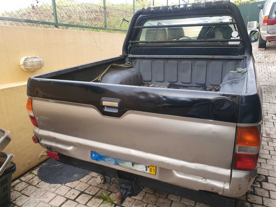 Mitsubishi L200 preta e prateada com engate de reboque
