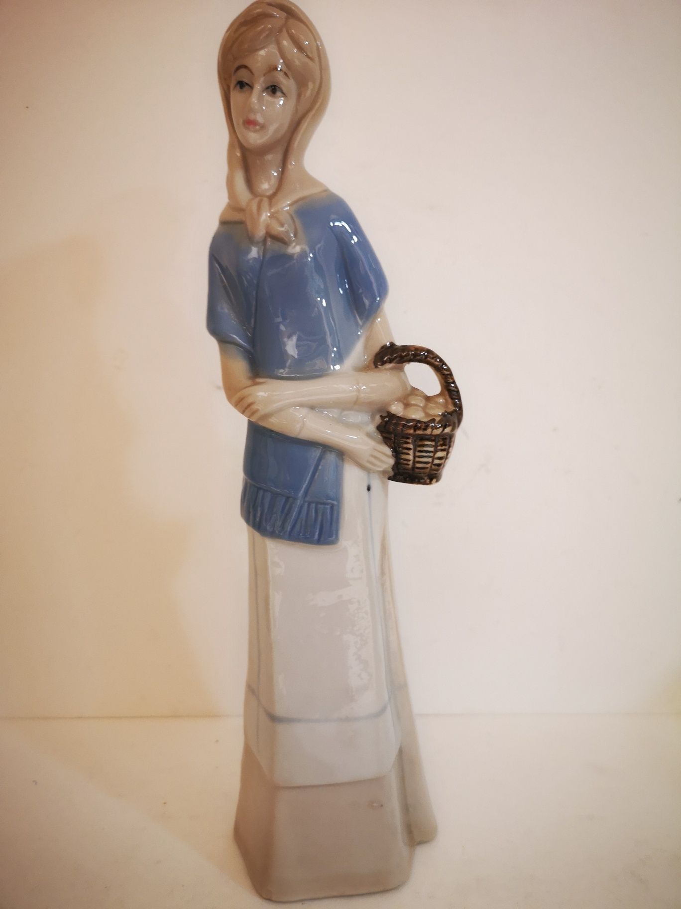 Porcelanowa figurka kobiety z jajkami w koszyku