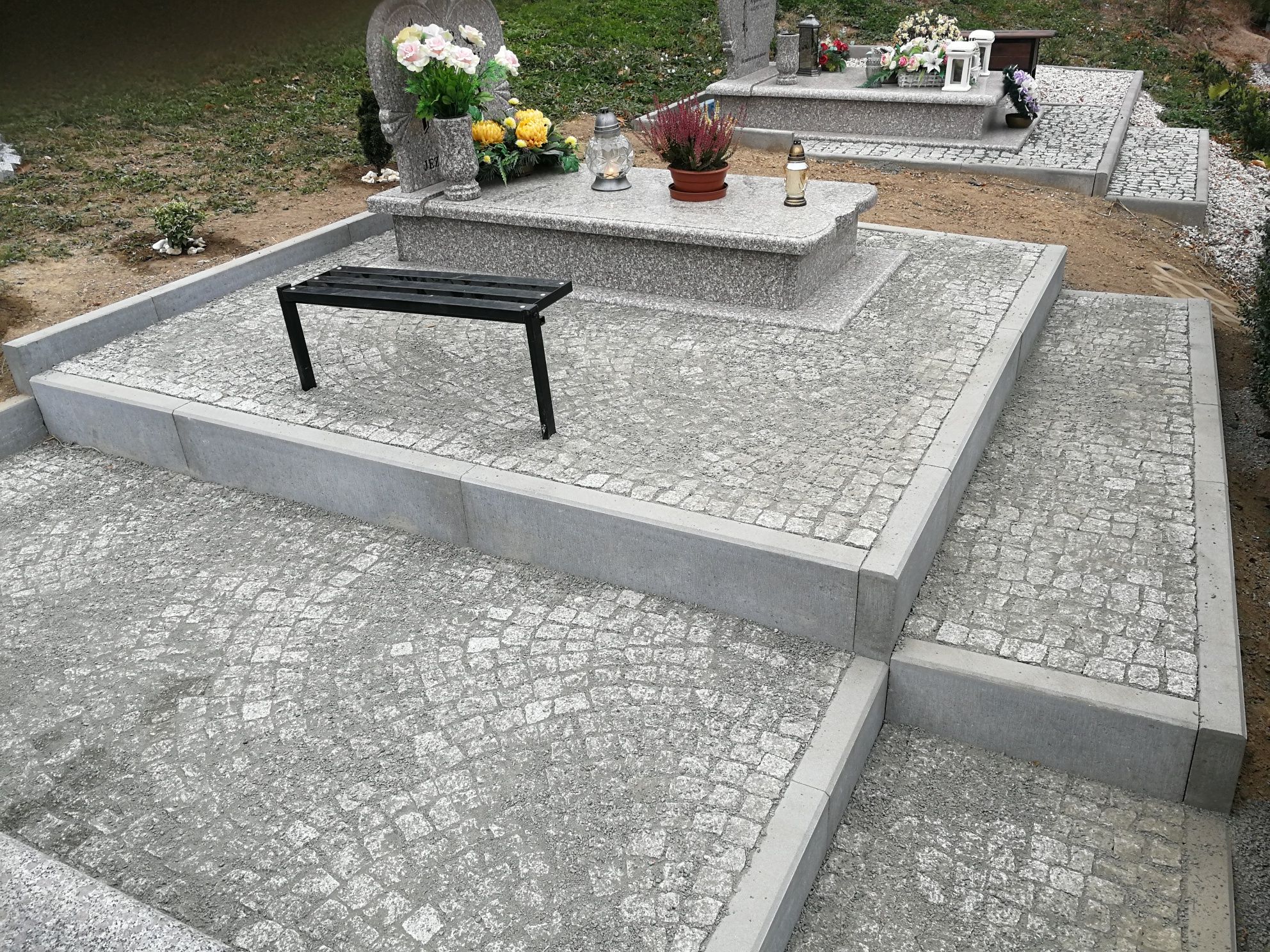 Kostka wokół grobów na cmentarzu/podnoszenie zapadniętych nagrobkow
