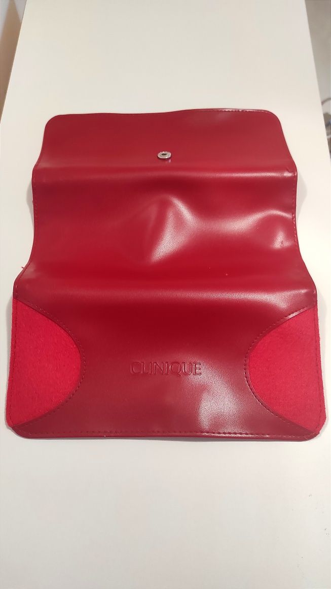Czerwona kosmetyczka Clinique, czerwony portfel