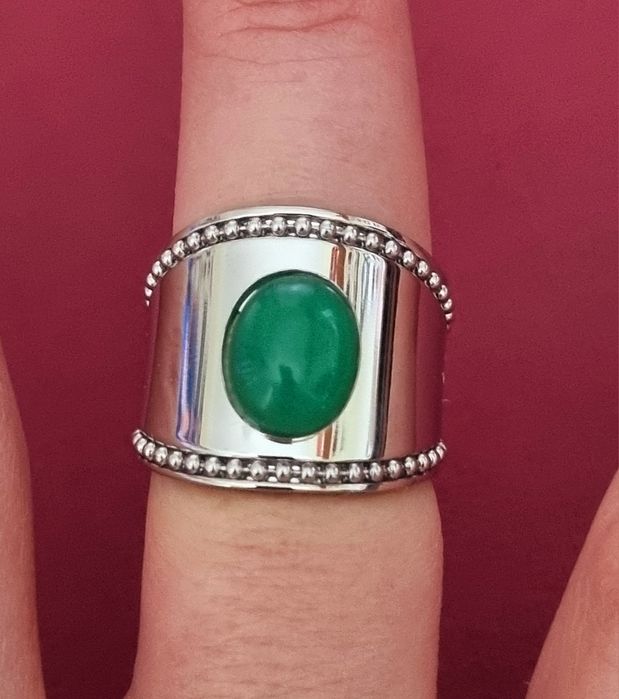 Anel prateado, em aço, com pedra oval verde. Ajustável