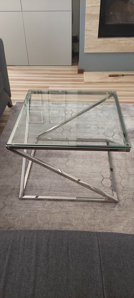 Nowoczesny stolik ze szklanym blatem i srebrną, metalową bazą
Stolik k