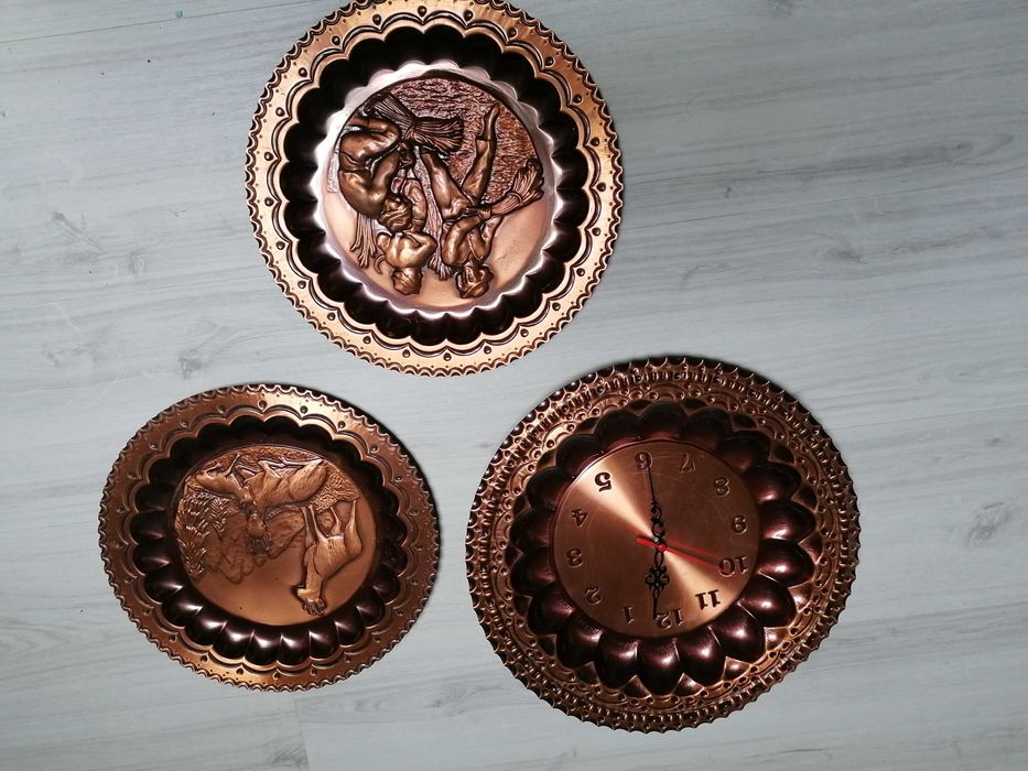 Pratos decorativos em cobre, sendo que um é relógio de parede.