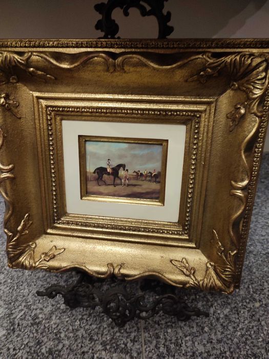 Quadro moldura em folha de ouro e gravura de cavalos. Vista ouro.