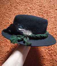 Чорний капелюх з фетра з пір'ям.