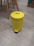 Caixote de lixo amarelo. Gato preto