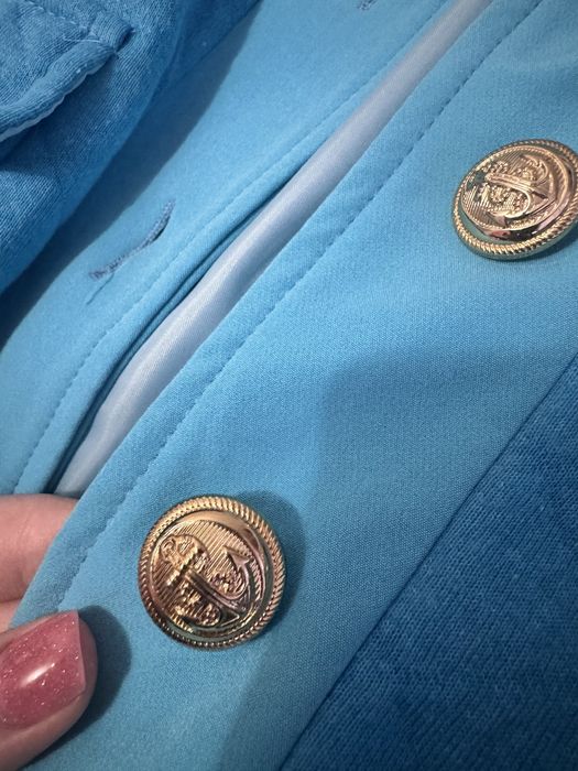 Стьобана куртка-бомбер бірюзового кольору із золотими ґудзиками.