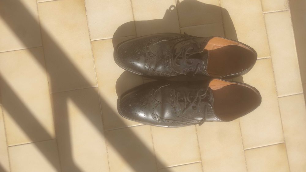 Sapatos pretos de atacadores