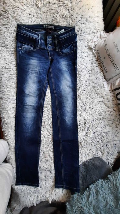 Spodnie jeansowe z wszytym paskiem cekinowym.