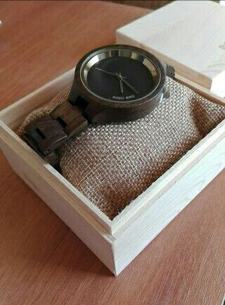 Ciemny drewniany zegarek w drewnianym pudełku na cienkim pasku