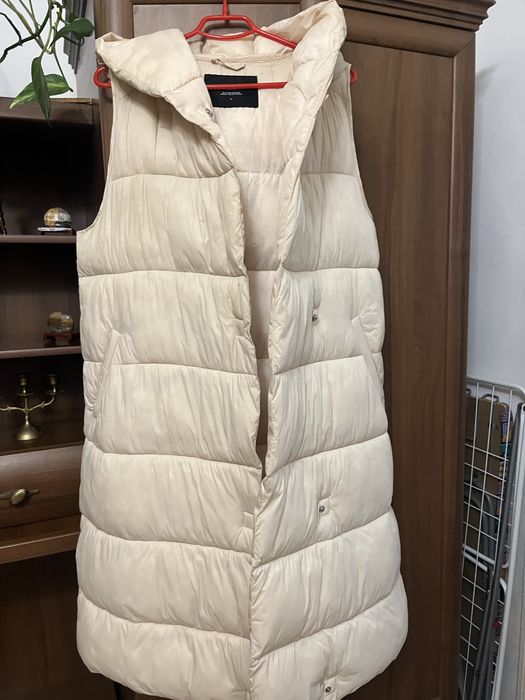 Безрукавка зимова, кремового кольору на закльопках