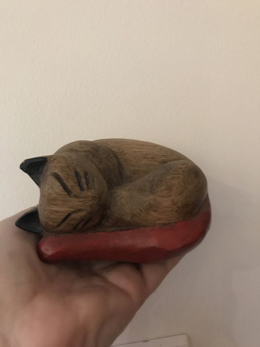 Rzeźba kota z czerwonym ogonem.