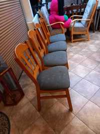 Cztery krzesła z tapicerowanym siedliskiem.