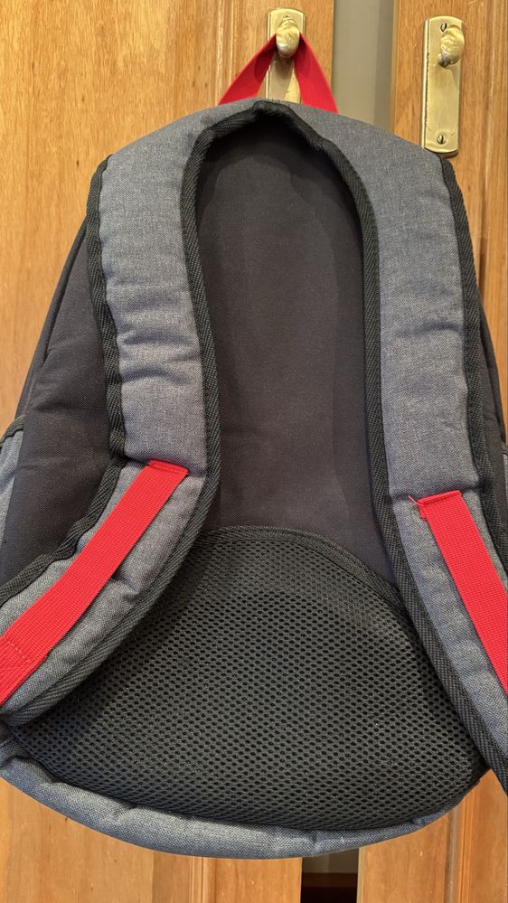 Mochila preta com os fechos em vermelho