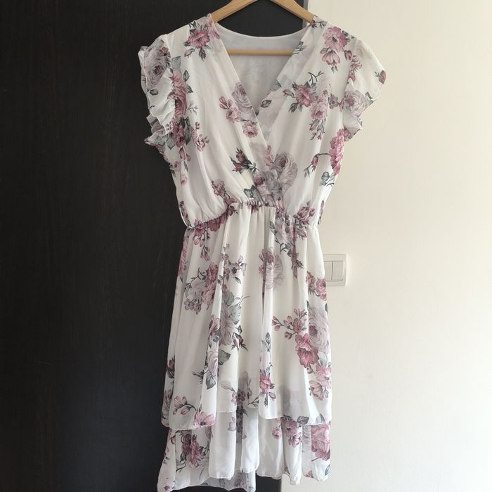 Biała sukienka w kwiaty z paskiem.