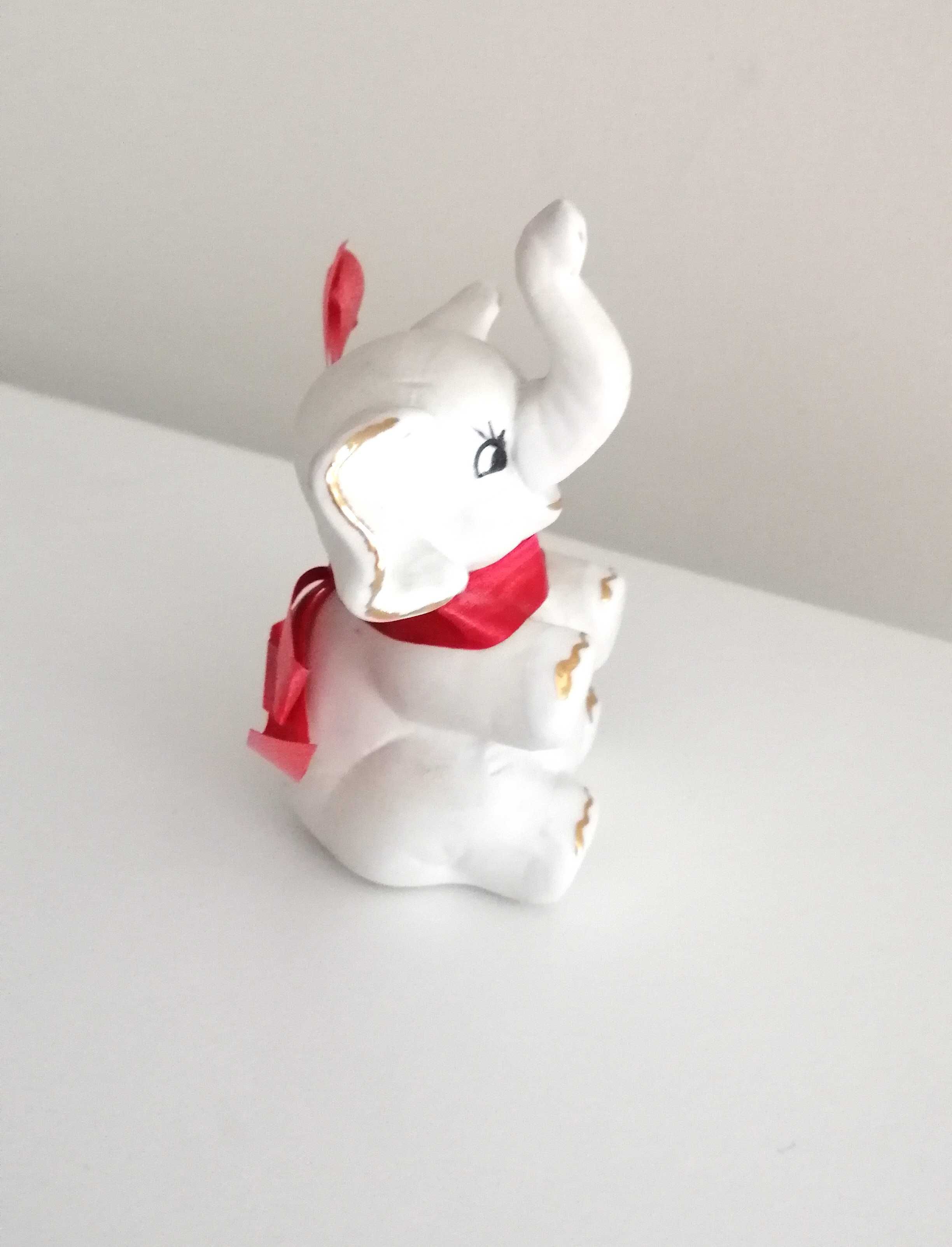 biały porcelanowy słonik z czerwoną kokardką na szczęście figurka