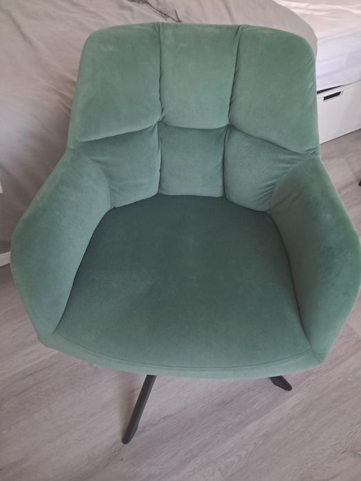 Cadeira giratória verde com pernas de aço preto.