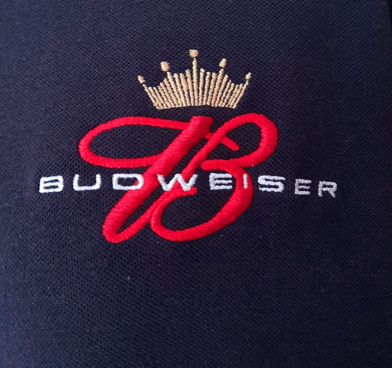 Polo Budweiser preto, com logótipo no peito. Tamanho L