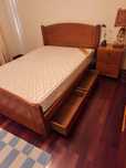 Quarto de casal com cama, colchão e mesinha em pinho mel