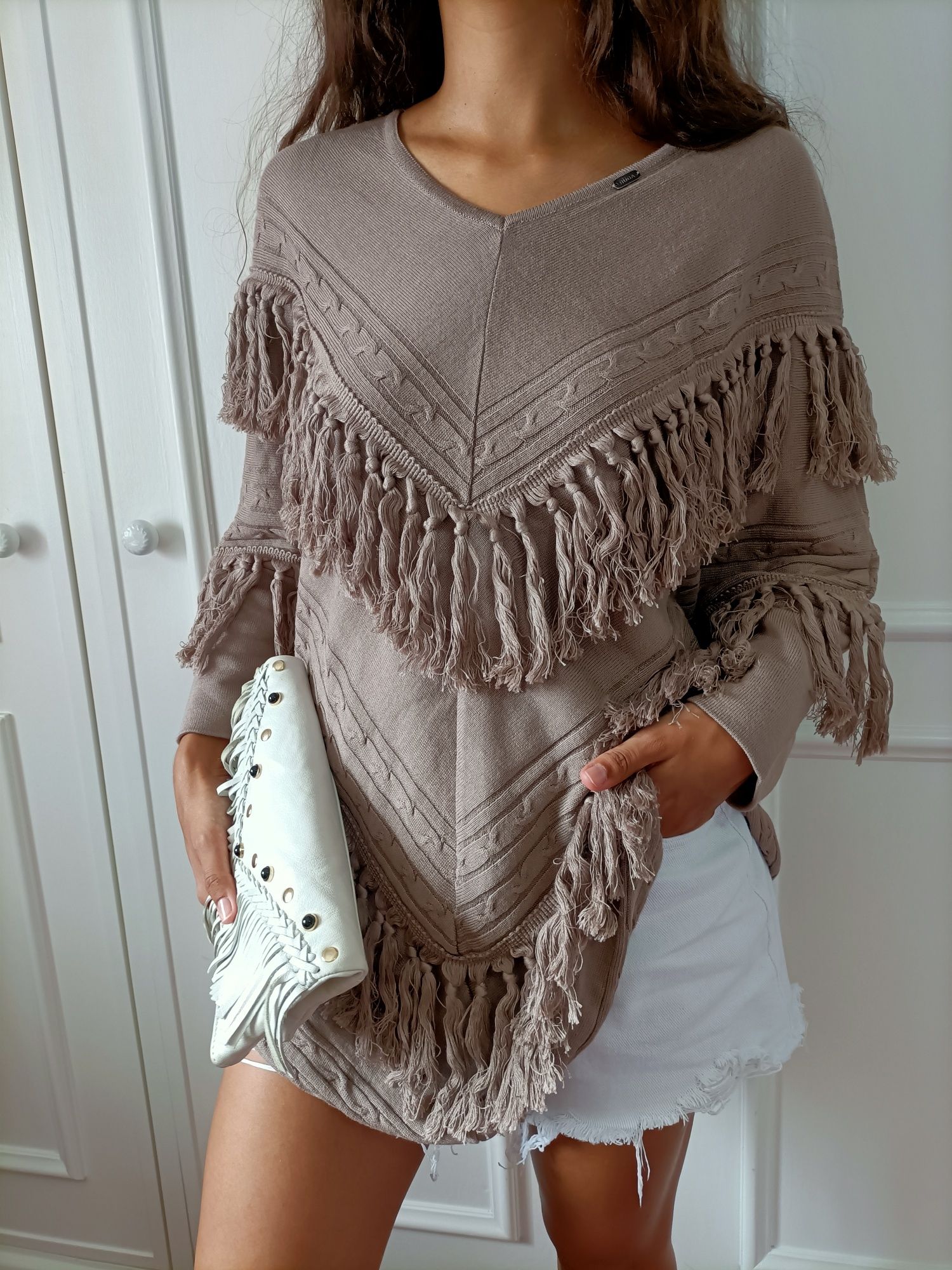 Camisola/poncho/capa com franjas da marca Ruga

Decote em V
Pormenor d