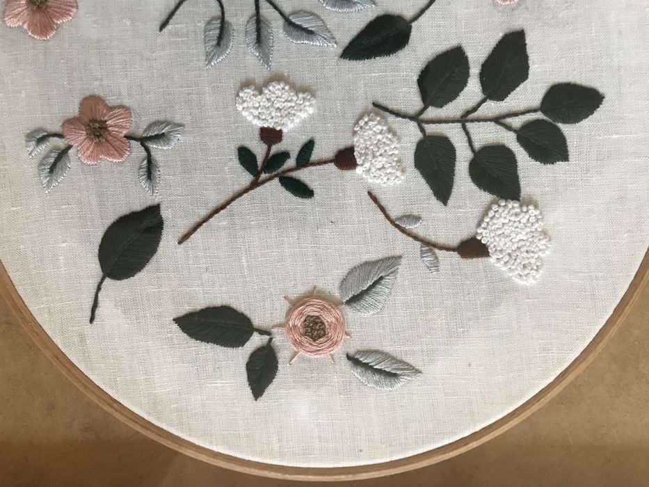 Quadros bordados à mão com motivos de flores.