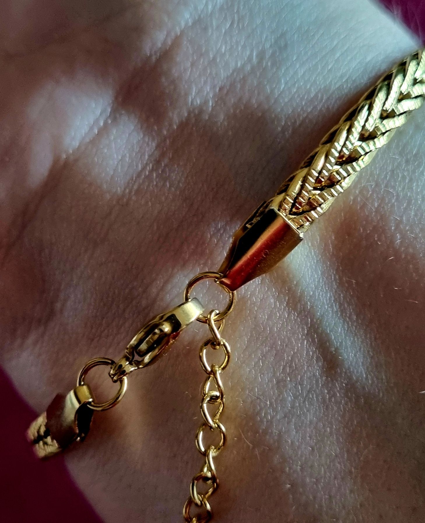 Pulseira dourada, em aço inoxidável. Tem extensor