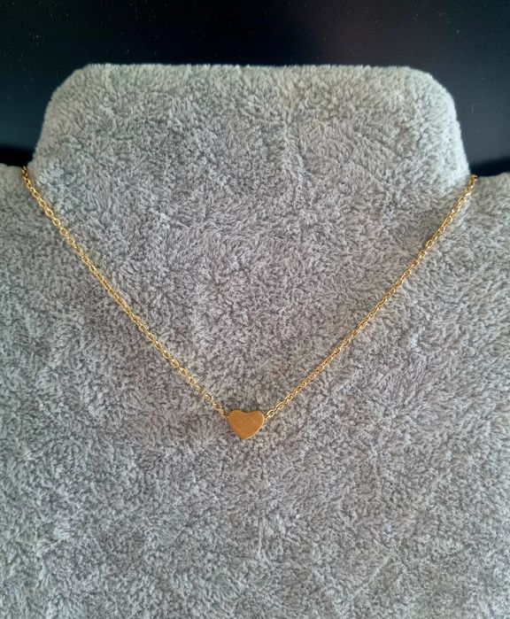 Colar dourado, em aço, com pequeno coração fixo. Tem extensor