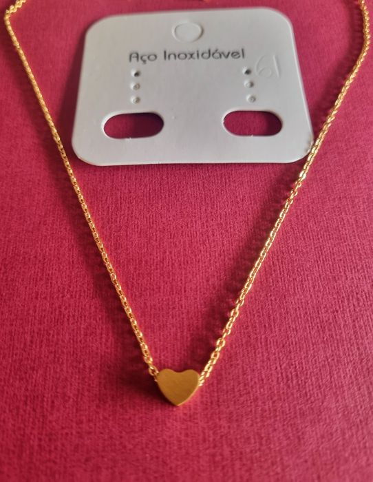 Colar dourado, em aço, com pequeno coração fixo. Tem extensor