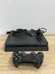 PlayStation 4 Slim 1TB z padem i okablowaniem – gotowa do grania!