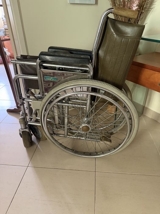 Cadeira de rodas com sinais de utilização mas resistente