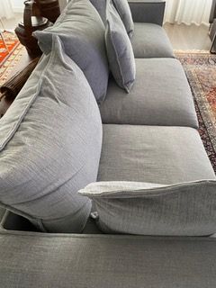 Enorme sofá em tecido cinzento