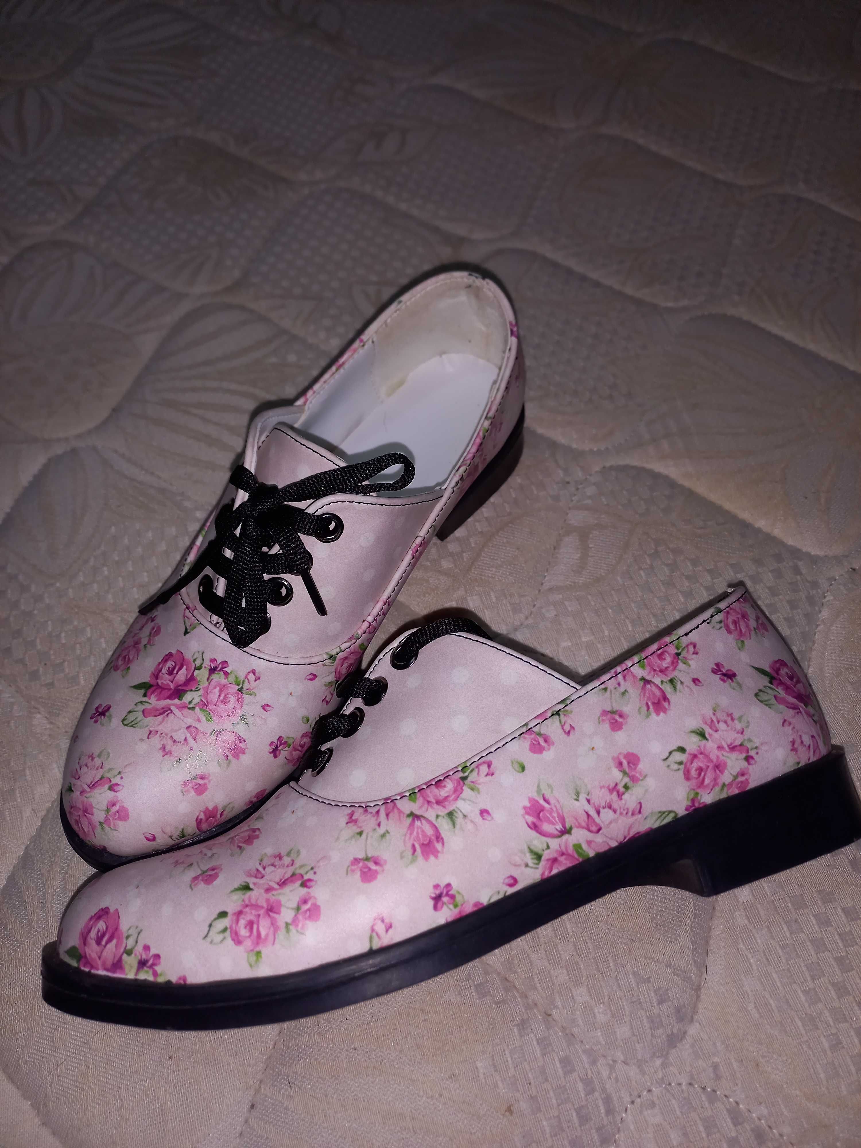 Sapatos novos rasos cor-de-rosa com flores.