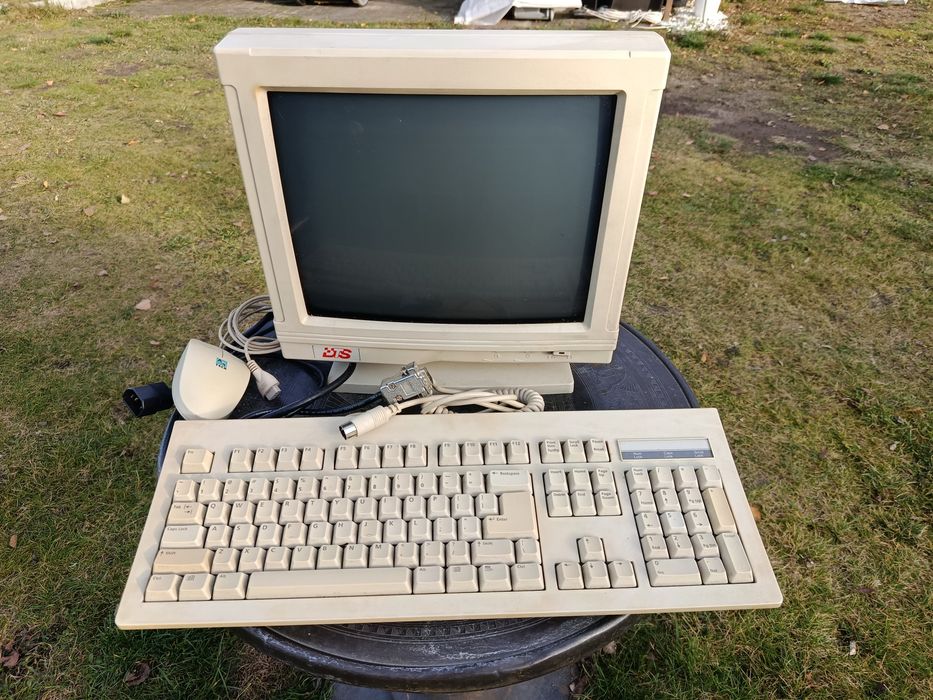 Stary monitor monochromatyczny DM-14SV1, wraz z klawiaturą i myszką.